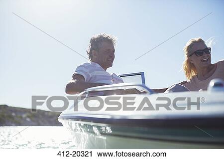 Stock Image - Couple riding in boat together . Fotosearch
