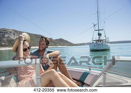 Stock Photography - Couple sitting in boat on water . Fotosearch