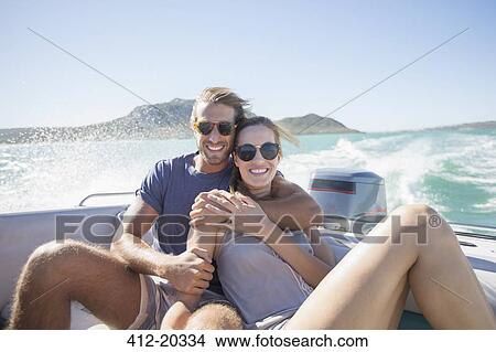 Picture - Couple sitting on boat together. Fotosearch
