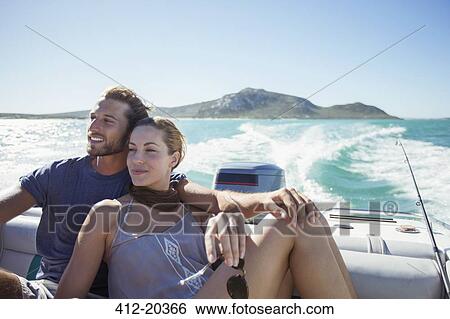 Stock Photograph - Couple sitting on boat together. Fotosearch