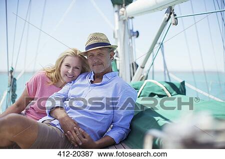 Couple sitting on deck of sailboat View Large Photo Image Stock Photo - Couple sitting on deck of sailboat. Fotosearch