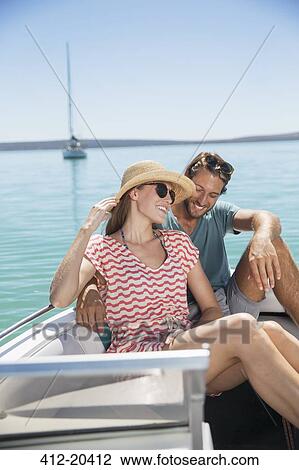 Couple sitting together in boat on water View Large Photo Image Stock Image - Couple sitting together in boat on water. Fotosearch