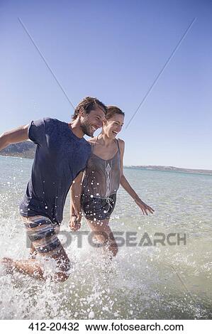 Couple splashing in water together View Large Photo Image Stock Image - Couple splashing in water together . Fotosearch
