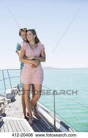 Stock Photograph - Couple standing on boat together. Fotosearch