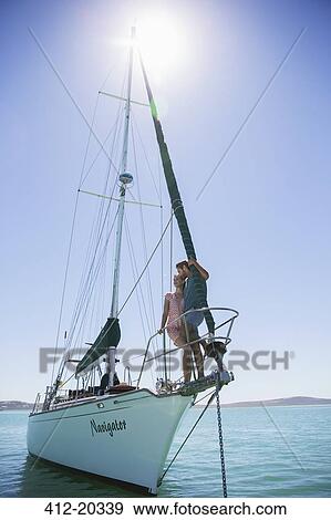 Stock Photo - Couple standing on end of boat . Fotosearch