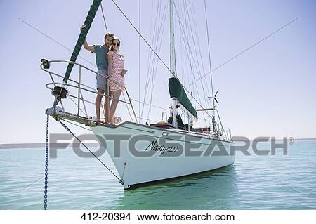 Picture - Couple standing on front of boat . Fotosearch
