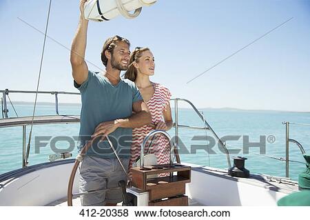 Stock Photo - Couple steering boat together . Fotosearch