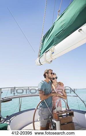 Stock Photography - Couple steering sailboat together . Fotosearch