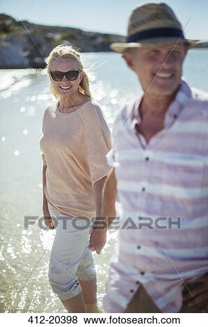 Stock Photo - Couple walking in water together. Fotosearch