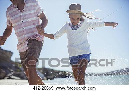 Family running in water on beach View Large Photo Image Stock Photo - Family running in water on beach. Fotosearch