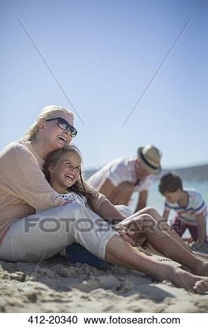Family sitting together on sandy beach  View Large Photo Image Stock Image - Family sitting together on sandy beach . Fotosearch