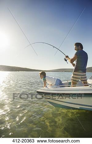 Stock Image - Father and son fishing on boat . Fotosearch