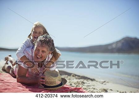Grandfather and granddaughter playing on beach View Large Photo Image Picture - Grandfather and granddaughter playing on beach. Fotosearch