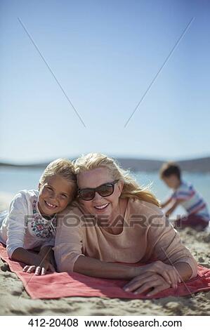 Grandmother and granddaughter laying on beach towel together View Large Photo Image Stock Photo - Grandmother and granddaughter laying on beach towel together . Fotosearch