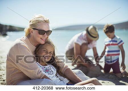 Grandmother hugging granddaughter on beach View Large Photo Image Stock Photo - Grandmother hugging granddaughter on beach. Fotosearch