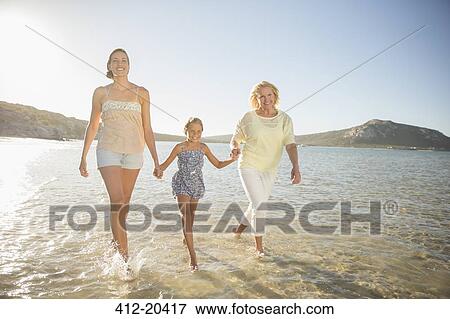 Three generations of women walking in waves View Large Photo Image Stock Photo - Three generations of women walking in waves. Fotosearch