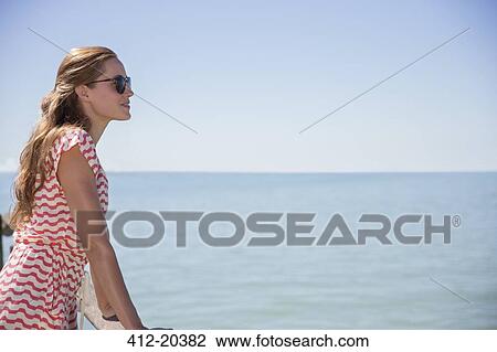 Stock Image - Woman standing next to water . Fotosearch
