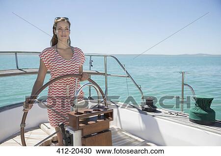 Woman steering boat on water View Large Photo Image Stock Image - Woman steering boat on water. Fotosearch