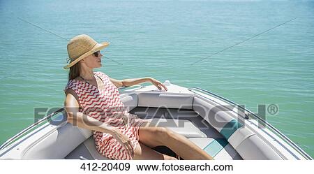 Stock Photo - Women relaxing in boat on water. Fotosearch