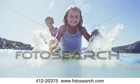 Young girl and brother splashing in water View Large Photo Image Stock Photography - Young girl and brother splashing in water . Fotosearch