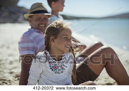 Young girl sitting with family on shore View Large Photo Image Stock Image - Young girl sitting with family on shore. Fotosearch