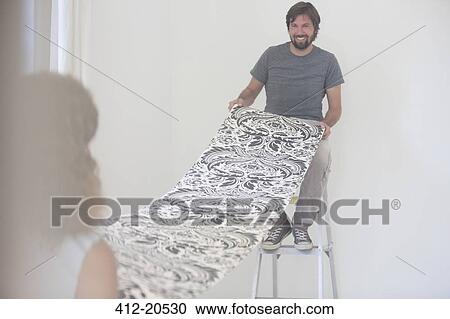 Couple hanging wallpaper together View Large Photo Image Stock Image - Couple hanging wallpaper together. Fotosearch