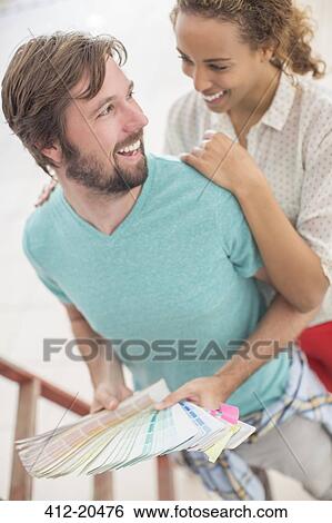 Couple hugging while observing color swatches together View Large Photo Image Stock Photograph - Couple hugging while observing color swatches together . Fotosearch