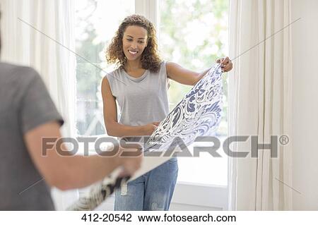 Couple laying out wallpaper together View Large Photo Image Stock Image - Couple laying out wallpaper together. Fotosearch