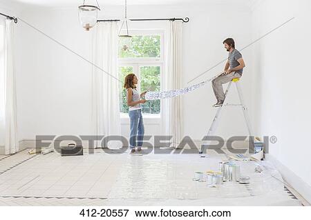 Couple laying out wallpaper together View Large Photo Image Stock Photo - Couple laying out wallpaper together. Fotosearch