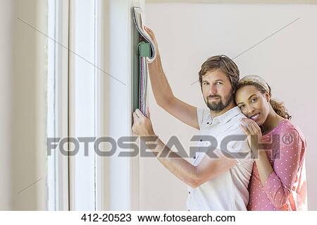 Stock Image - Couple looking through fabric swatches together . Fotosearch