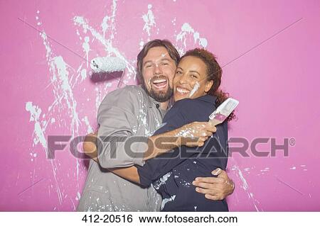 Couple playing with painting wall View Large Photo Image Stock Photograph - Couple playing with painting wall . Fotosearch