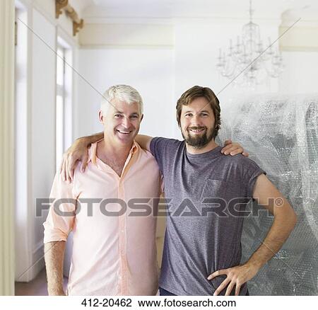 Stock Image - Father and son hugging indoors. Fotosearch