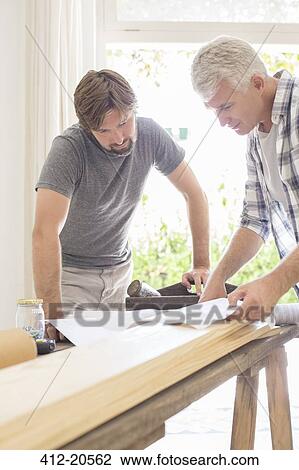 Father and son looking through documents View Large Photo Image Stock Image - Father and son looking through documents . Fotosearch