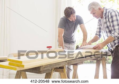Stock Photo - Father and son looking through construction plans . Fotosearch