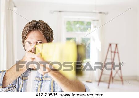 Stock Photography - Man holding wood close to face . Fotosearch
