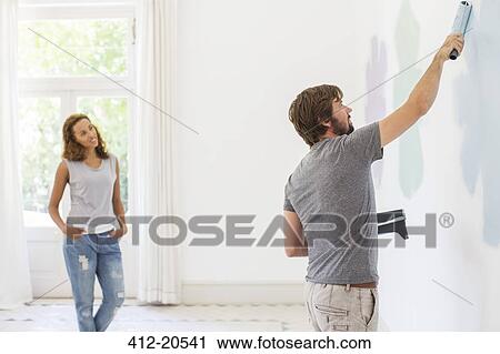 Man painting wall with girlfriend observing View Large Photo Image Stock Image - Man painting wall with girlfriend observing. Fotosearch