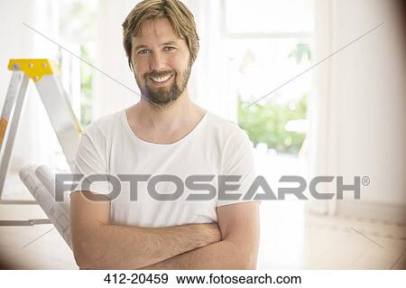 Man smiling near ladder in empty room View Large Photo Image Stock Photo - Man smiling near ladder in empty room . Fotosearch