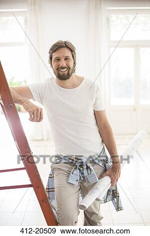 Man standing on ladder in living space View Large Photo Image Stock Photo - Man standing on ladder in living space. Fotosearch