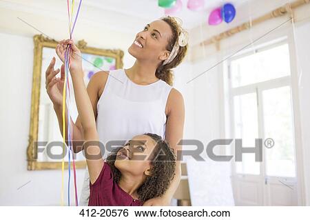 Mother and daughter holding balloons together View Large Photo Image Stock Photograph - Mother and daughter holding balloons together . Fotosearch