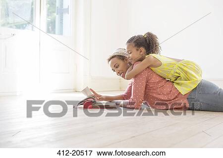 Stock Photo - Mother and daughter looking through fabric swatches together. Fotosearch
