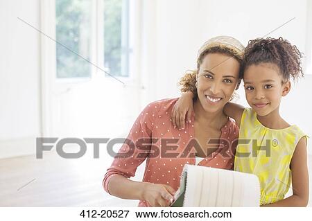 Stock Photo - Mother and daughter looking through fabric swatches . Fotosearch