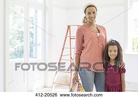 Stock Photograph - Mother and daughter smiling in living space . Fotosearch