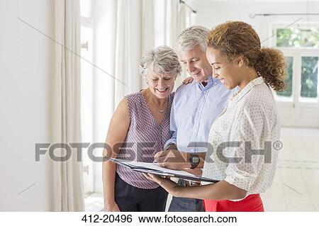Stock Photograph - Older couple and woman signing documents. Fotosearch