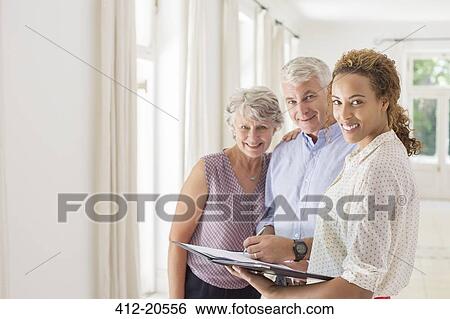 Stock Photograph - Older couple and woman signing documents. Fotosearch