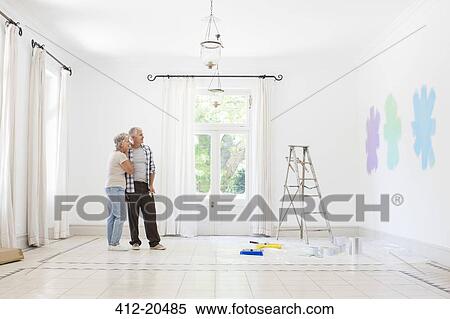 Stock Photography - Older couple looking at paint swatches together. Fotosearch