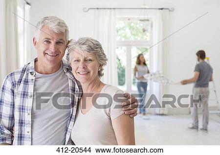 Picture - Older couple smiling together in living space . Fotosearch