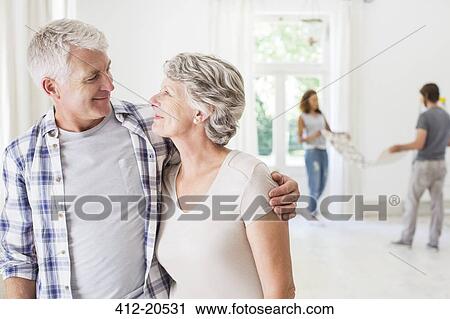 Older couple smiling together in living space View Large Photo Image Stock Image - Older couple smiling together in living space . Fotosearch