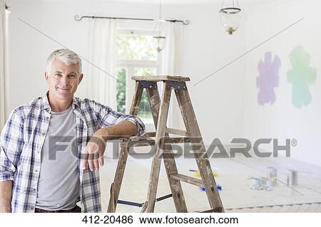 Older man smiling near ladder in livingroom View Large Photo Image Stock Photograph - Older man smiling near ladder in livingroom . Fotosearch