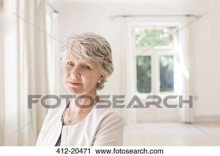 Older woman in empty living room View Large Photo Image Stock Image - Older woman in empty living room. Fotosearch