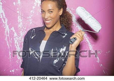 Picture - Woman painting pink wall . Fotosearch